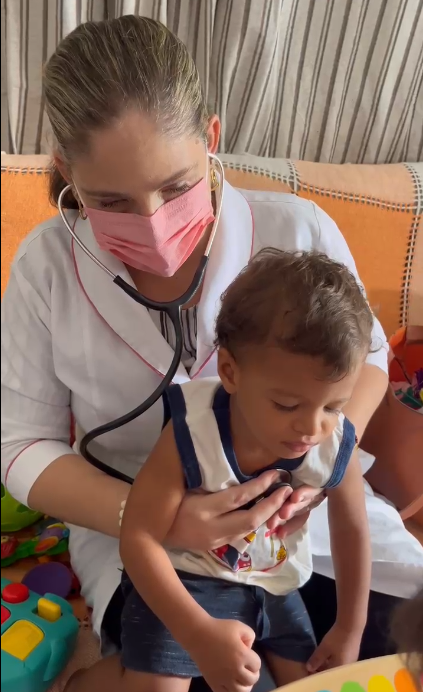 Patrícia Mendonça auscultando uma criança com estetoscópio